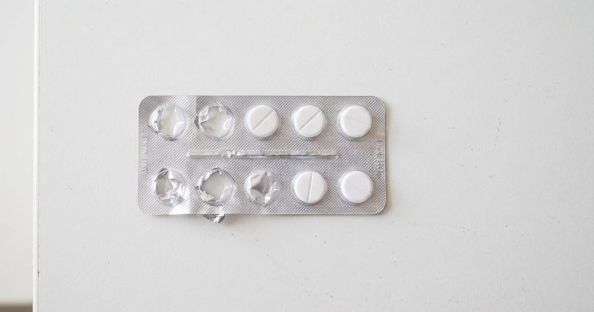Plaquette de comprimés blancs posée sur un comptoir de pharmacie, ambiance sobre et professionnelle