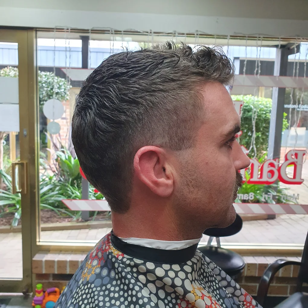 A young boy smiling after getting a stylish new haircut.