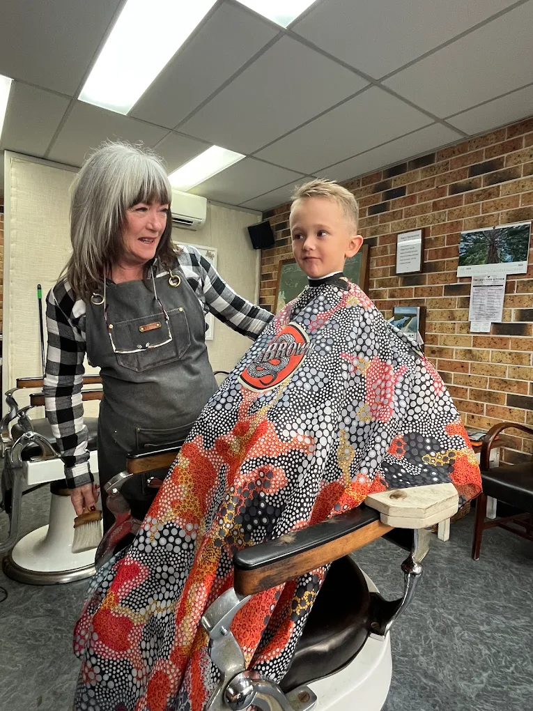 Portrait of a smiling barber, Ivan, holding his tools.