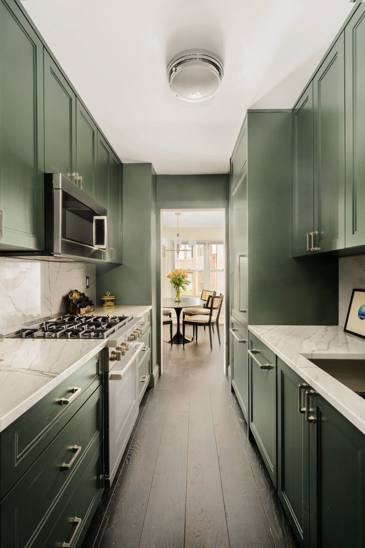 The kitchen: deep green custom cabinetry and marble countertops