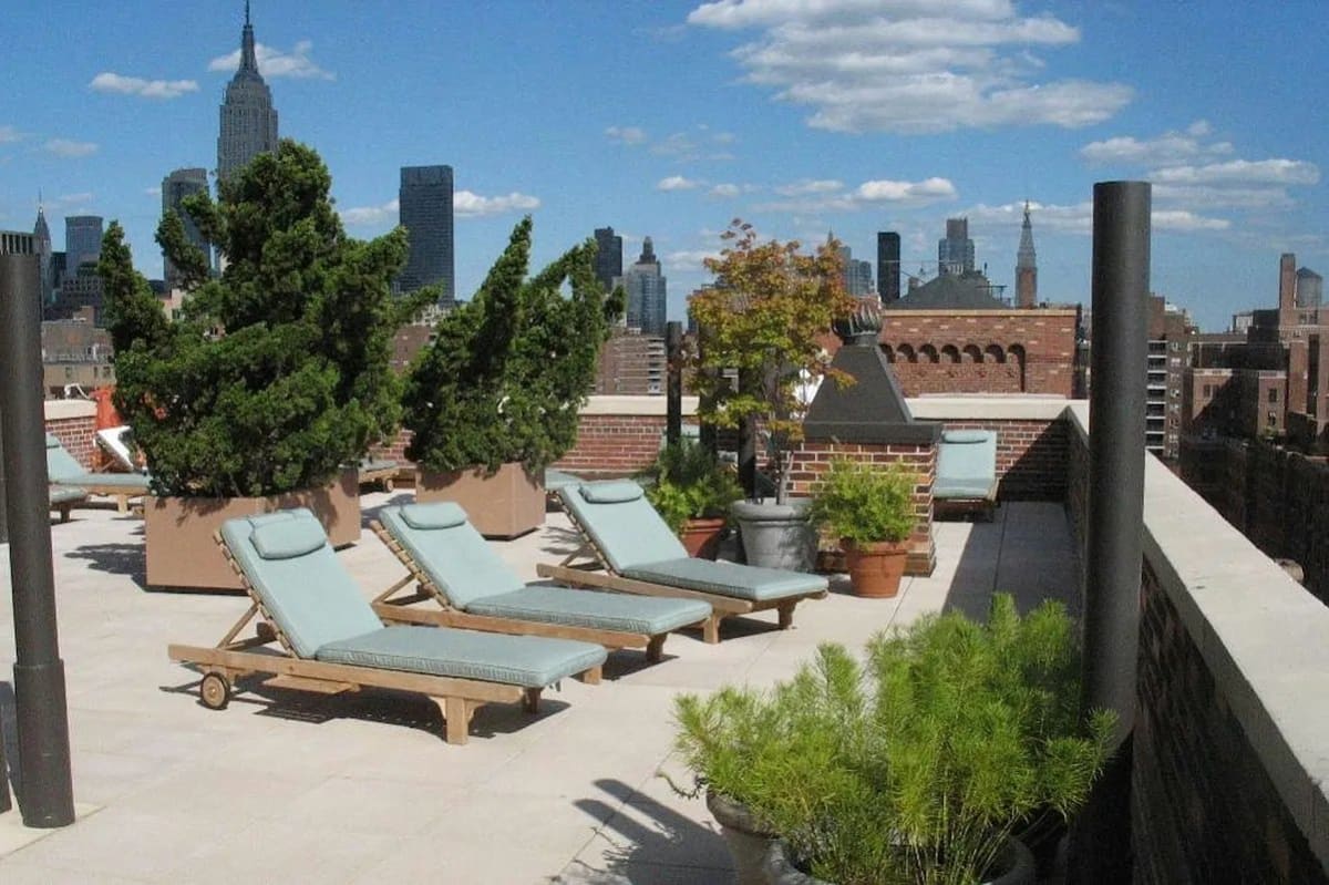 Lounge chairs on the planted London Terrace roof deck, the Midtown skyline beyond