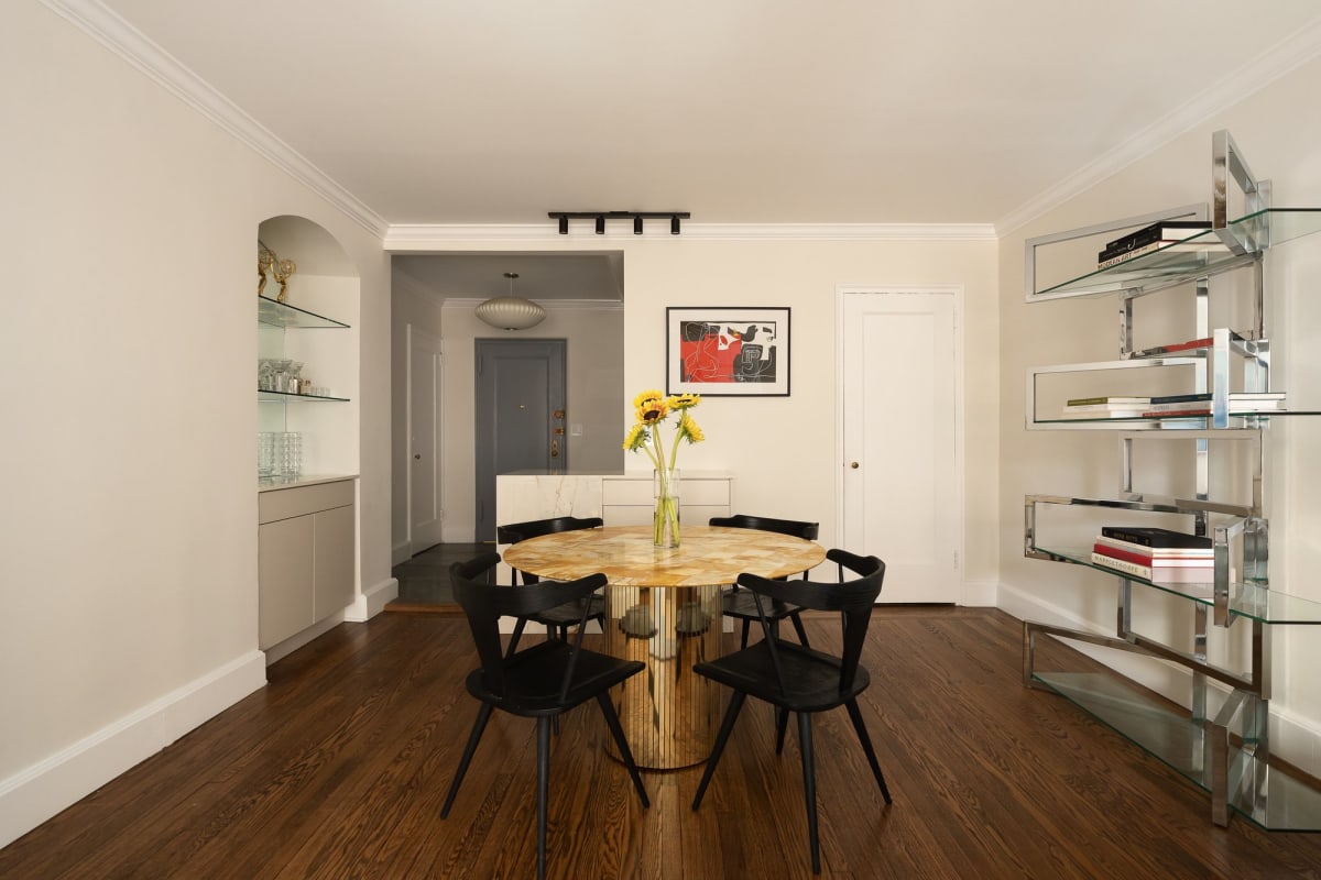 The dining area of Residence 16J with round table, the entry foyer beyond