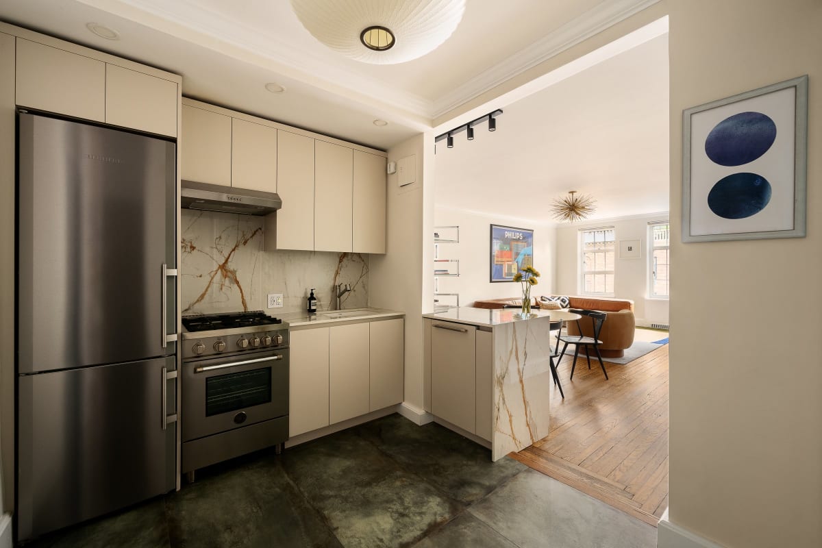 The renovated kitchen with island, Liebherr refrigerator and Bertazzoni range, open to the living room