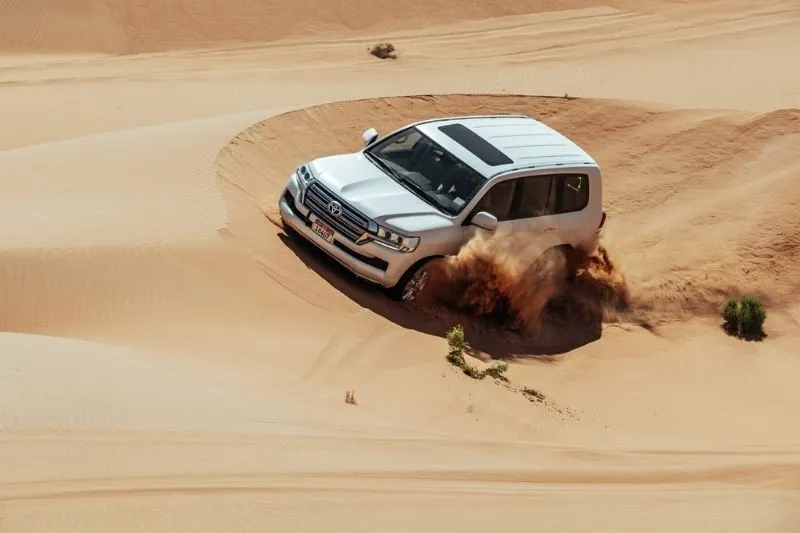 Dune bashing in 4x4 Land Cruiser at sunrise in Al Khatim Desert, Abu Dhabi