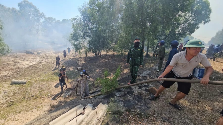 Người dân địa phương cùng lực lượng chức năng tham gia dập lửa ở xã Triệu Cơ - Ảnh: Lê Trường
