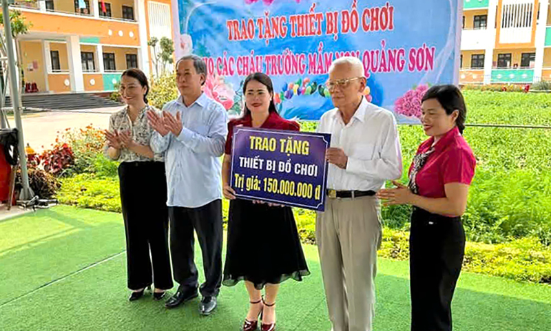 Đồng chí Trung tướng Mai Xuân Vĩnh tặng quà cho trường Mầm non xã Quảng Sơn.