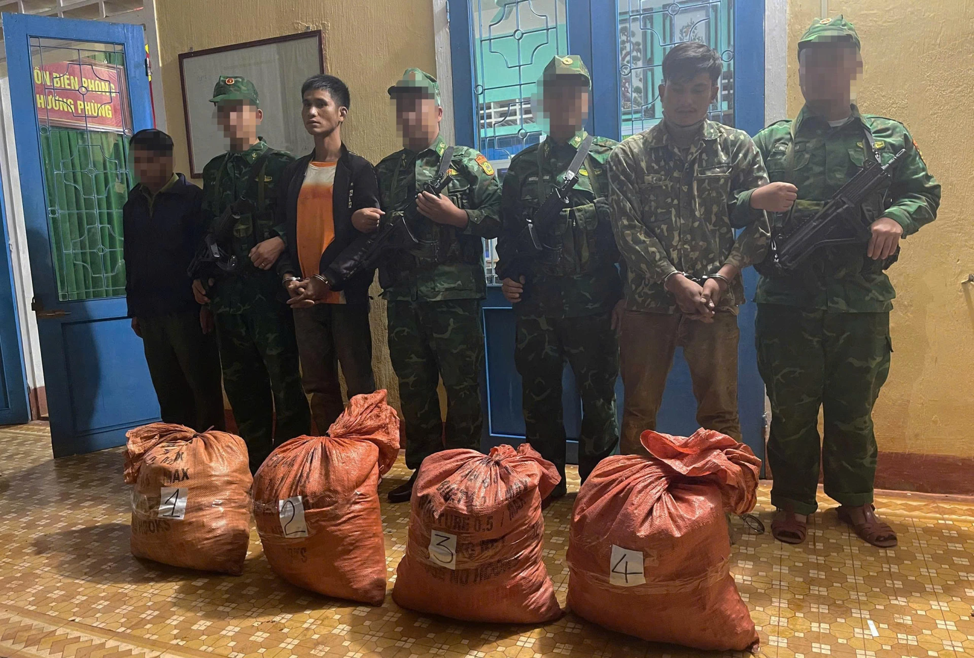 Hình ảnh hai đối tượng người Lào cùng tang vật 160kg vật liệu nổ bị lực lượng chức năng thu giữ.