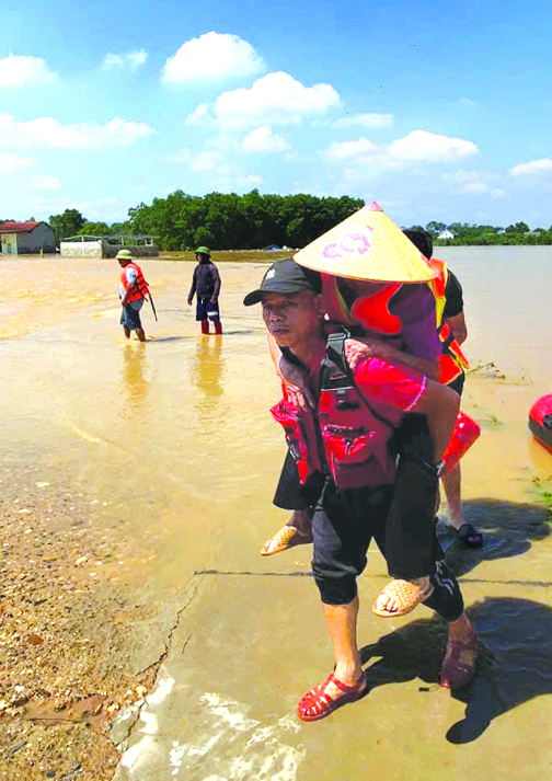 Anh Mậu Tuấn tận tình cõng một người cao tuổi từ vùng ngập sâu Thái Nguyên đến nơi an toàn - Ảnh: NVCC