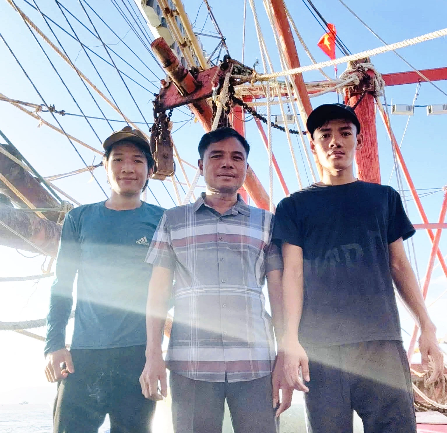 Ông Hồ Đăng Vỏ (người ở giữa) cùng hai con trai trên tàu cá QB92981TS - Ảnh: T.L