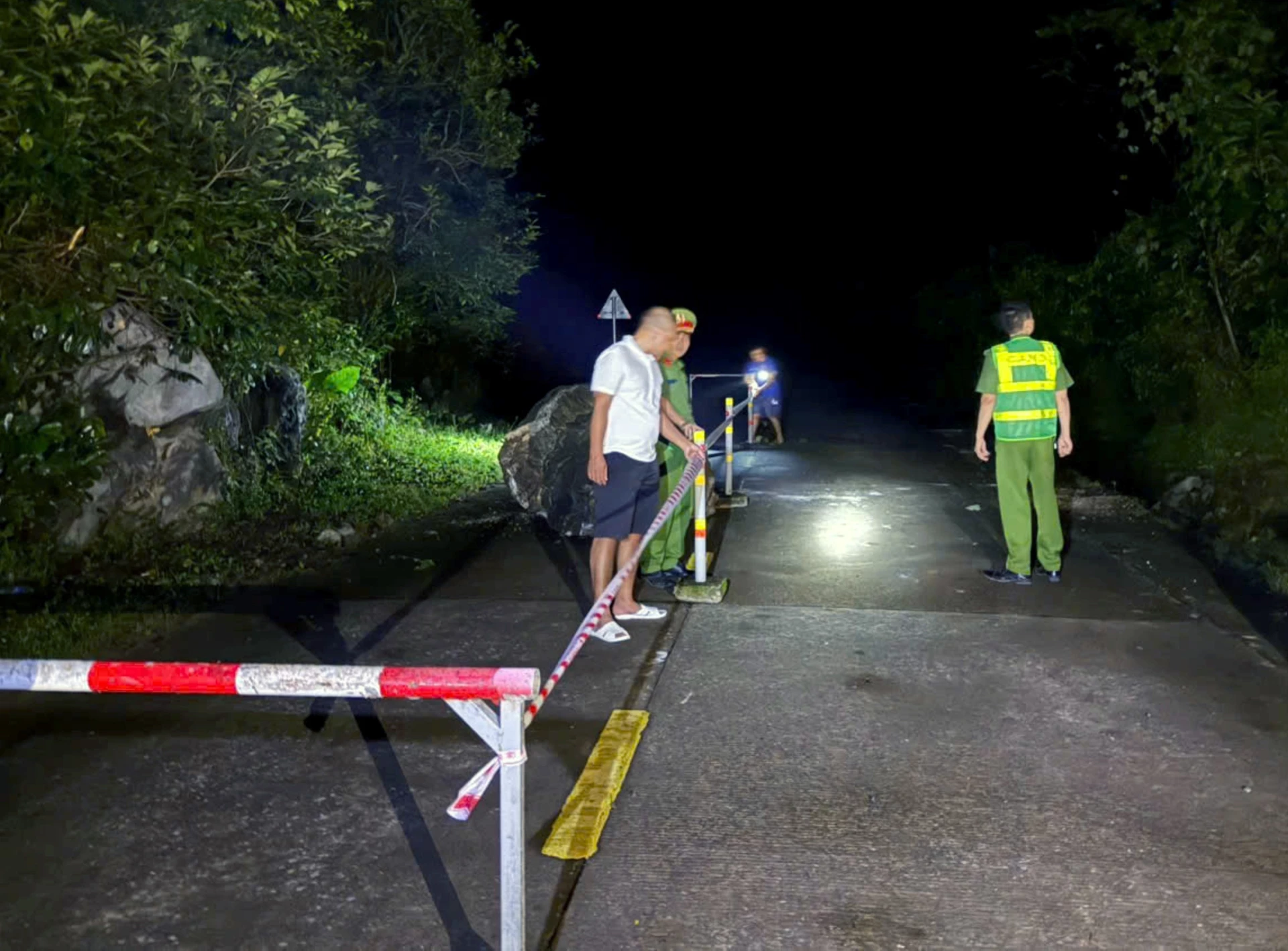 Lực lượng chức năng tiến hành làm rào chắn và cắm biển cảnh báo tại khu vực xảy ra sạt sở - Ảnh: CTV