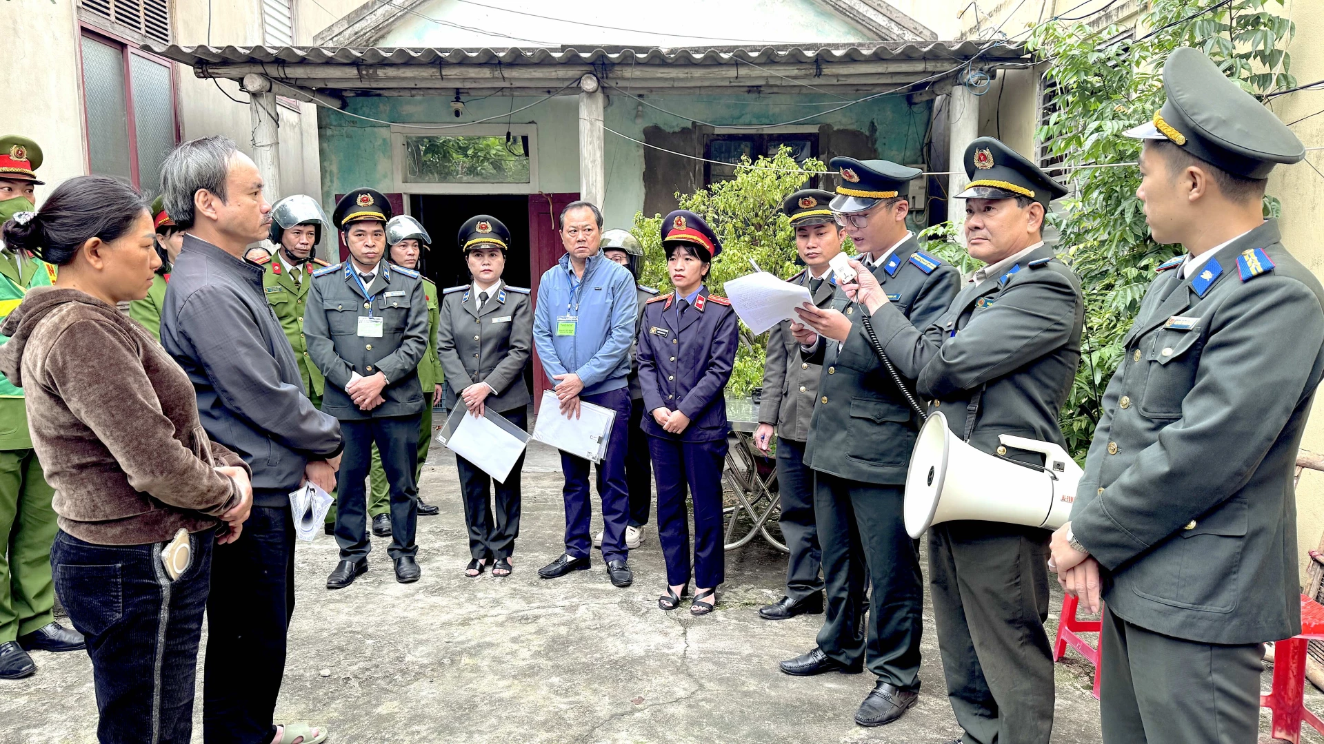 Thi hành án dân sự tỉnh Quảng Trị đọc Quyết định cưỡng chế thi hành án đối với ông Trần Văn Thân và bà Đặng Thị Dung tại địa chỉ ngõ 37 Tôn Thất Thuyết, phường Đồng Hới. Ảnh: Quang Ngọc