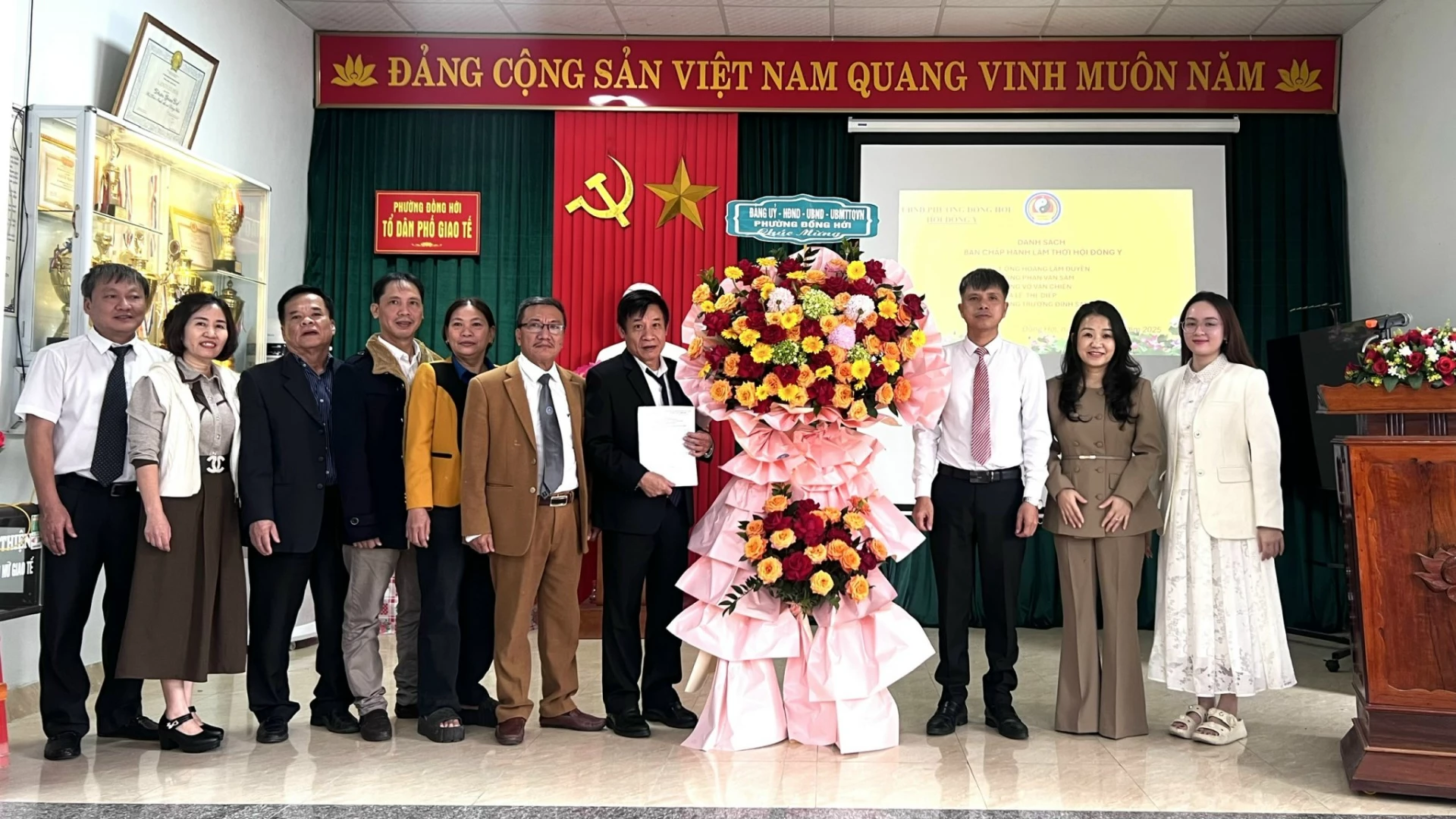 Đại diện UBND phường Đồng Hới tặng hoa chúc mừng Hội Đông y phường Đồng Hới - Ảnh: H.T