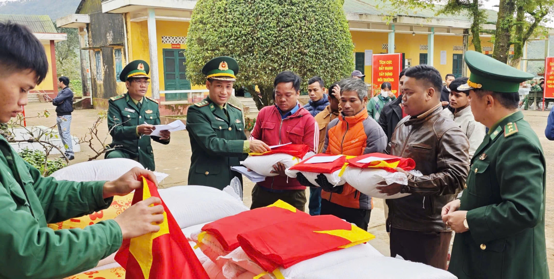 Cán bộ, chiến sĩ Đồn Biên phòng Ba Nang trao tận tay những bao gạo và lá cờ Tổ quốc do các nhà tài trợ gửi đến cho người dân xã Đakrông-Ảnh: K.S