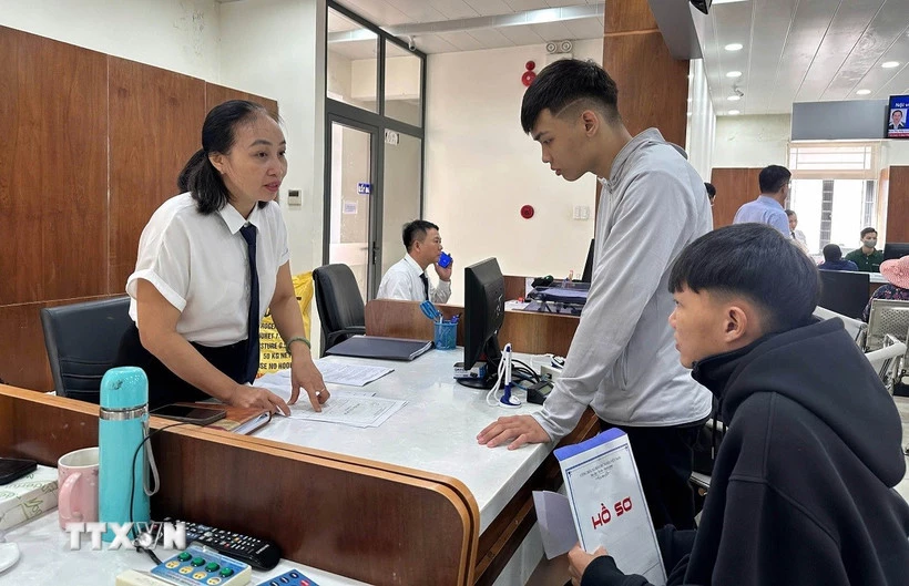 Cán bộ Trung tâm hành chính công phường Tam Kỳ, thành phố Đà Nẵng, hướng dẫn người dân làm thủ tục hành chính. (Ảnh: Trần Tĩnh/TTXVN)