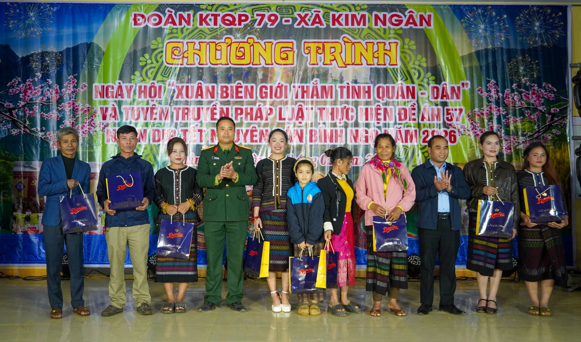 Đại diện Ban Chỉ huy Đoàn Kinh tế-Quốc phòng 79 cùng lãnh đạo địa phương trao tặng quà cho các hộ gia đình sinh sống tại bản Km14, xã Kim Ngân - Ảnh: N.H