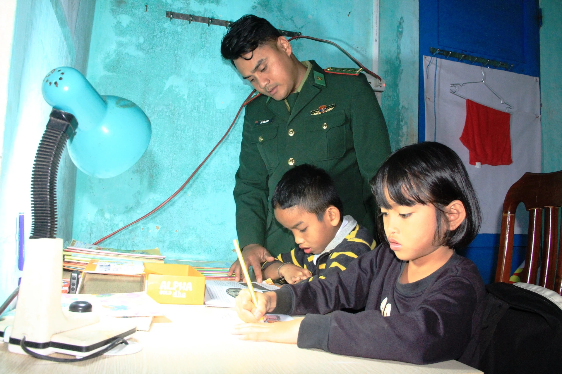 Anh em Tuấn và Tuyền được cán bộ biên phòng kèm cặp học tập - Ảnh: ĐV