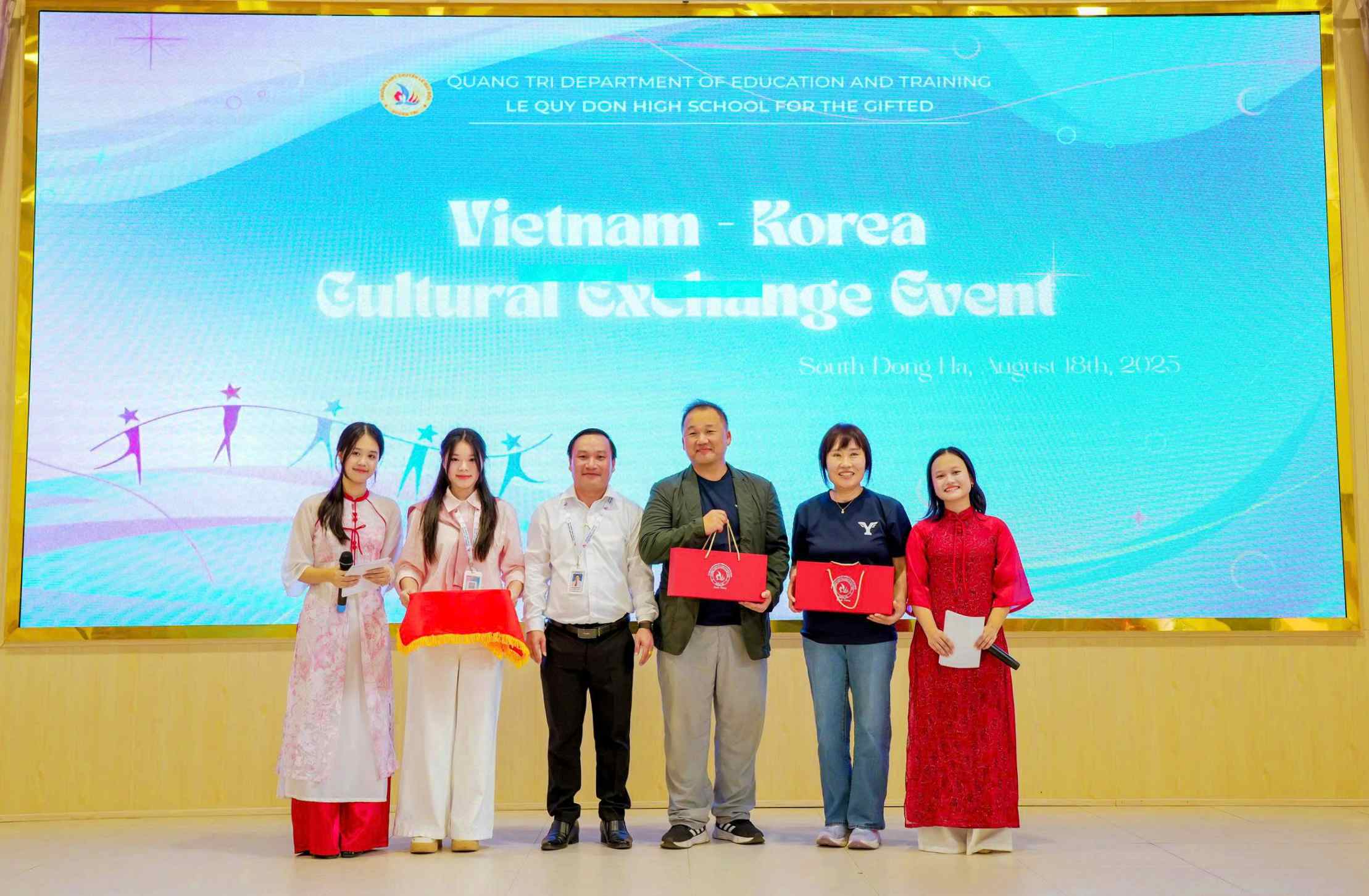 Thầy Ngô Quang Minh Hải (đứng thứ 3, từ trái sang) tặng quà cho những người bạn Nhật Bản đến thăm, làm việc tại Trường THPT chuyên Lê Quý Đôn - Ảnh: Q.H