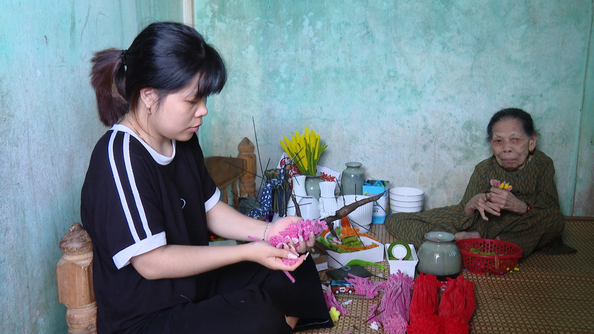 Chị Lê Thị Minh Hậu đang làm hoa cùng bà ngoại -Ảnh: N.D