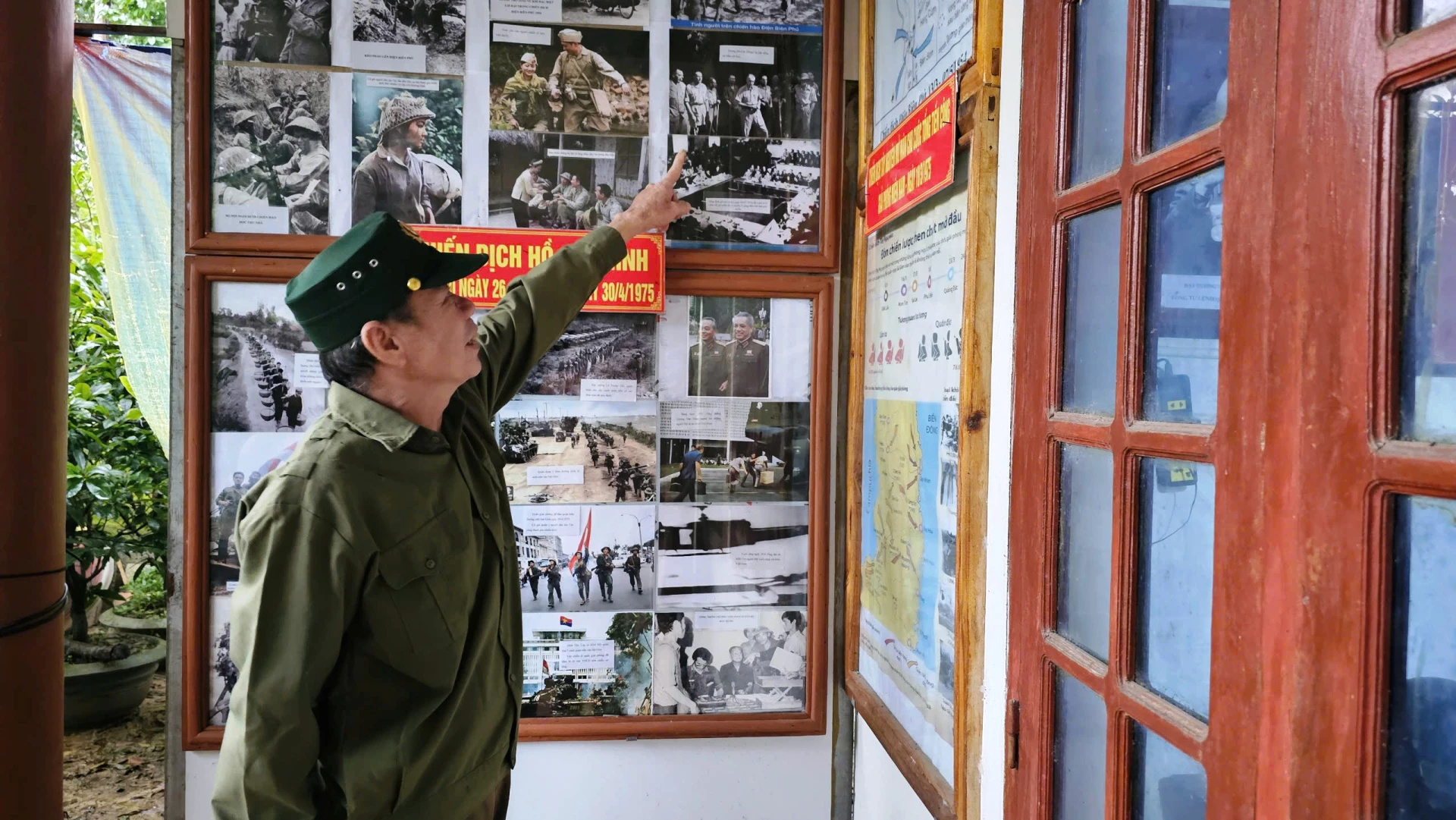 Ông Hoàng Chiến Sỹ say mê bên những bức ảnh tư liệu lịch sử được ông dày công sưu tầm và gìn giữ qua nhiều thập kỷ - Ảnh: T.T