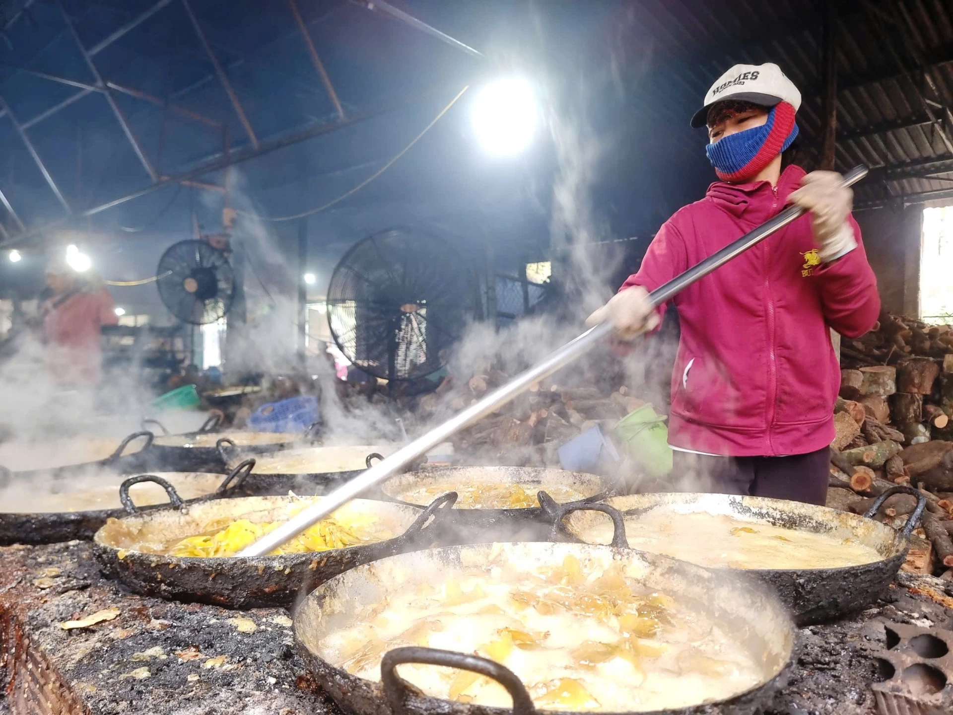 Nhân công miệt mài đảo rim mứt gừng trên bếp lửa tại cơ sở của bà Võ Thị Tâm, thôn Mỹ Chánh, xã Nam Hải Lăng - Ảnh: ĐV