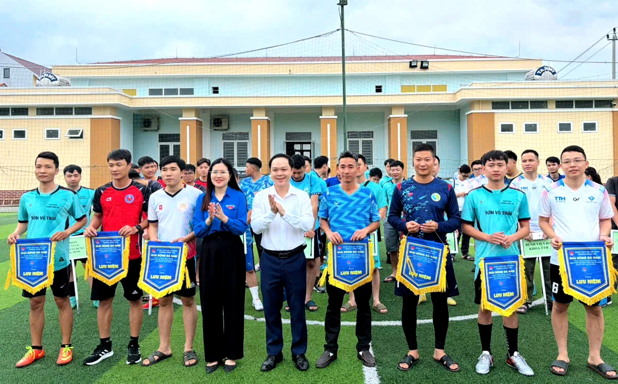 Đại diện lãnh đạo phường Đồng Hới và Đoàn phường trao cờ lưu niệm cho các đội tuyển tham gia giải bóng đá nam. - Ảnh: H.Tr