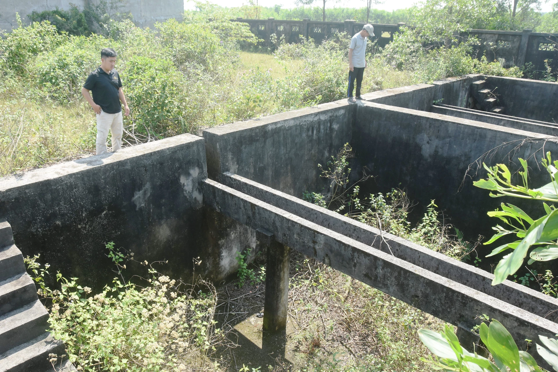 Hạng mục bể chứa nước của dự án Hệ thống cấp nước xã Hải Chánh (cũ) cỏ mọc um tùm, có dấu hiệu xuống cấp - Ảnh: Đ.V