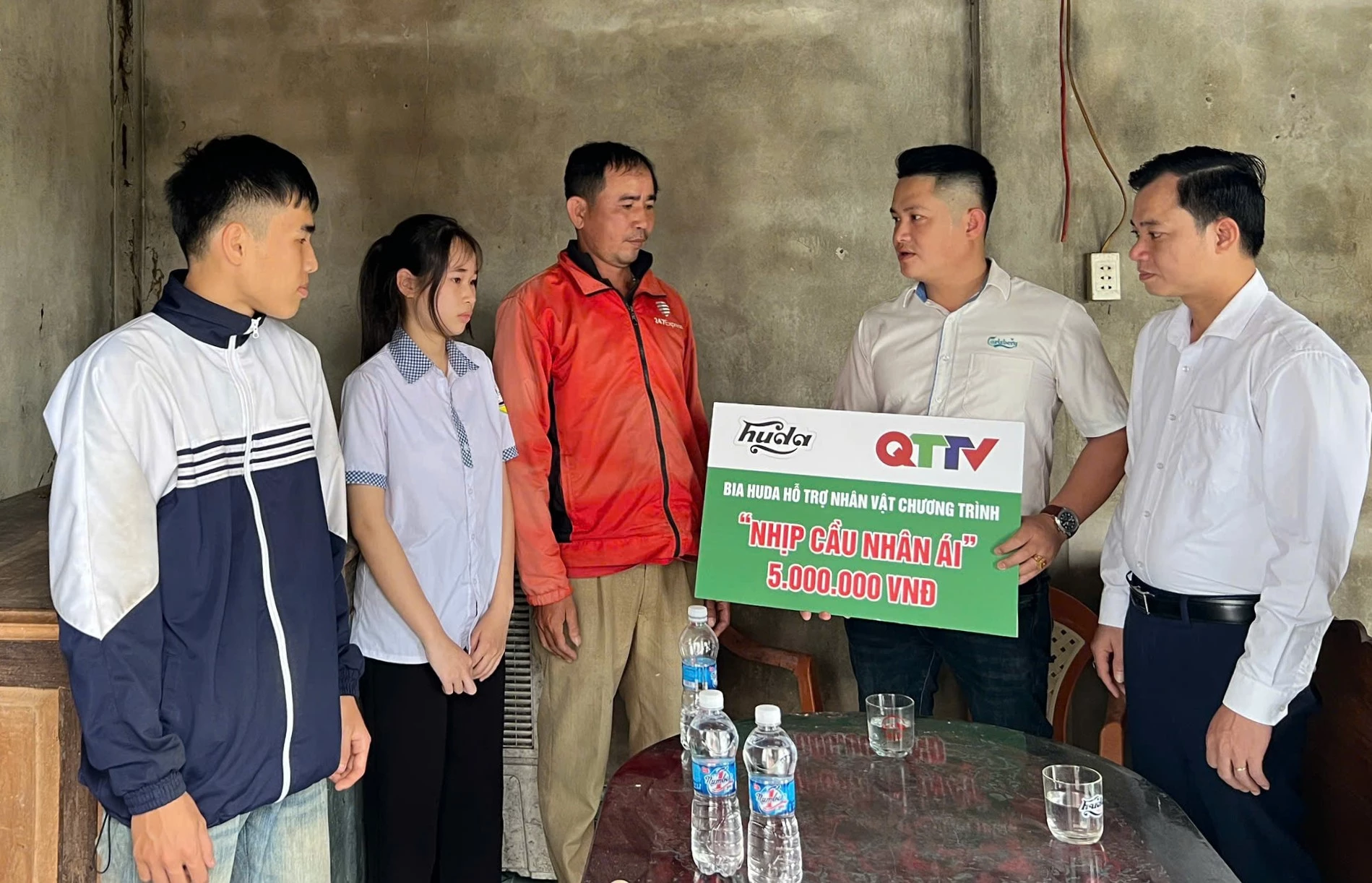 Đại diện Nhãn hàng Bia Huda trao hỗ trợ 5 triệu đồng cho anh Nguyễn Văn Phú (thôn Vĩnh Tuy 1, xã Quảng Ninh) - Ảnh: H.C