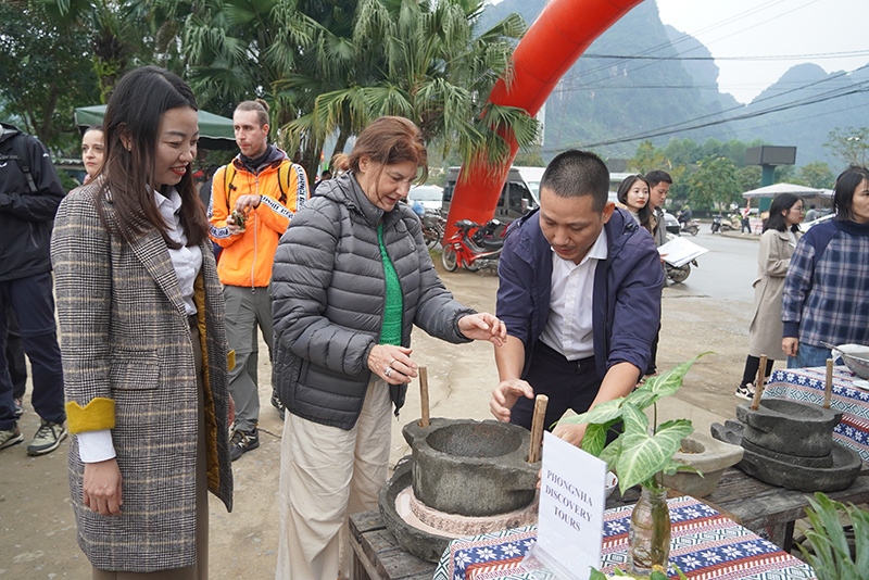 Du khách nước ngoài thích thú với các dụng cụ chế biến nguyên liệu làm thức ăn.