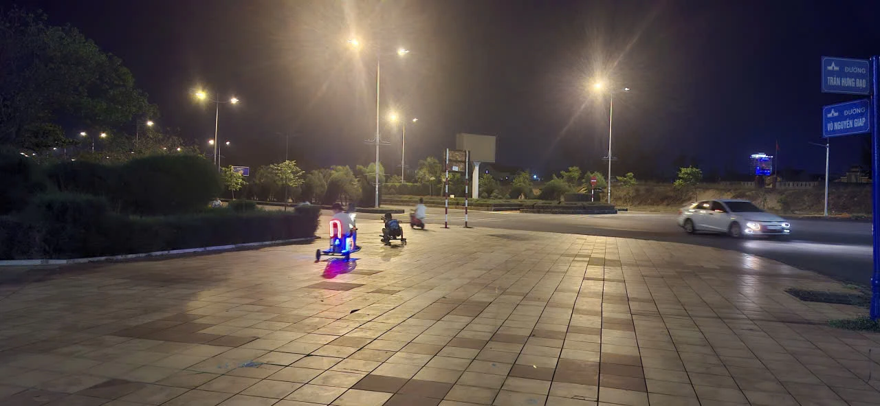 Hình ảnh một bên là xe điện mini do trẻ em điều khiển trên vỉa hè, bên còn lại là đường giao thông tấp nập với nhiều phương tiện đang lưu thông - Ảnh: M.N