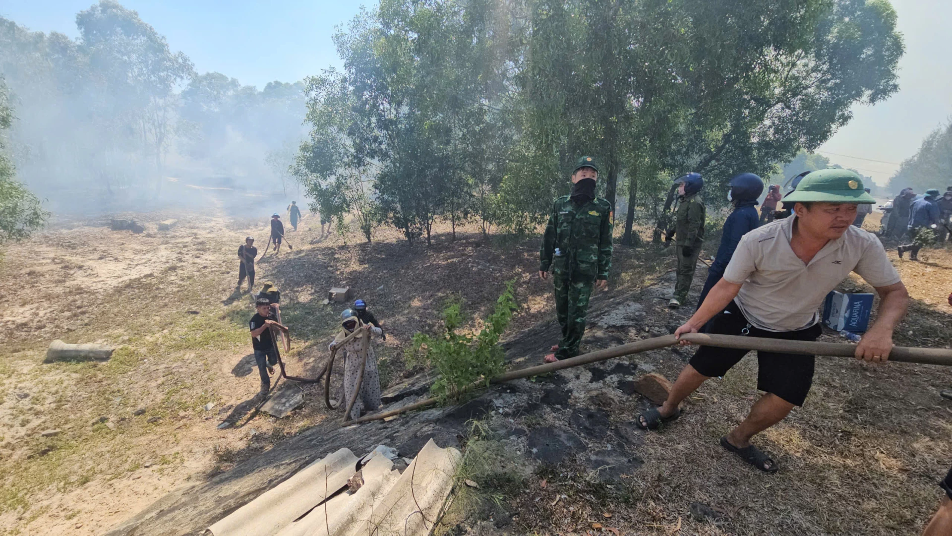 Người dân địa phương cùng lực lượng chức năng tham gia dập lửa ở xã Triệu Cơ - Ảnh: Lê Trường