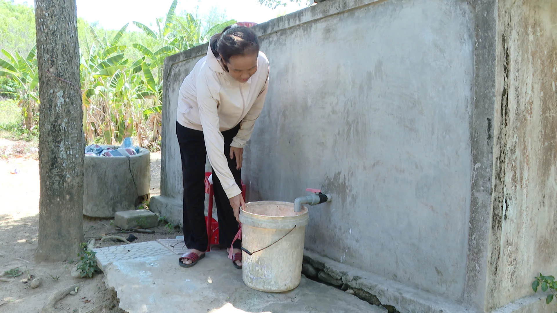 Bà Phan Thị Bảy phải mua nước tích trữ trong các bể chứa để sử dụng-Ảnh: T.T