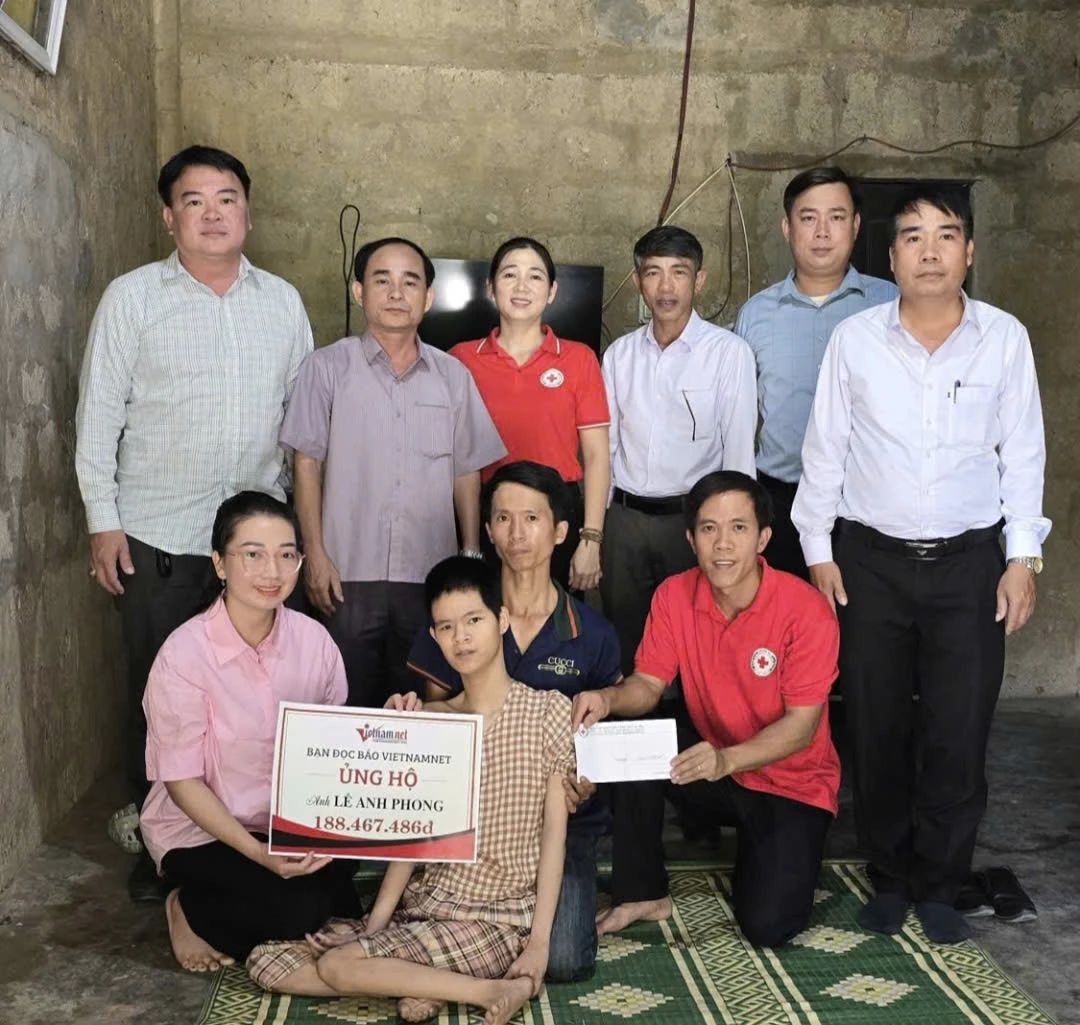Nhà báo Hương Lài (hàng đầu, thứ nhất, từ trái sang) thay mặt bạn đọc Báo VietNamNet trao số tiền ủng hộ cho gia đình cần giúp đỡ tại Quảng Trị - Ảnh: NVCC