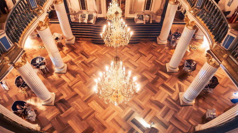 Eleganter Ballsaal mit Royals, Kronleuchtern und einer großen Treppe