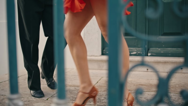 Close-up of the legs of a couple performing Latin American dances on the street