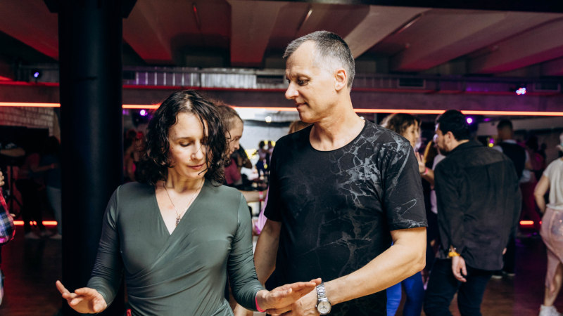 Un uomo e una donna ballano la Bachata su una pista da ballo durante un evento serale latinoamericano