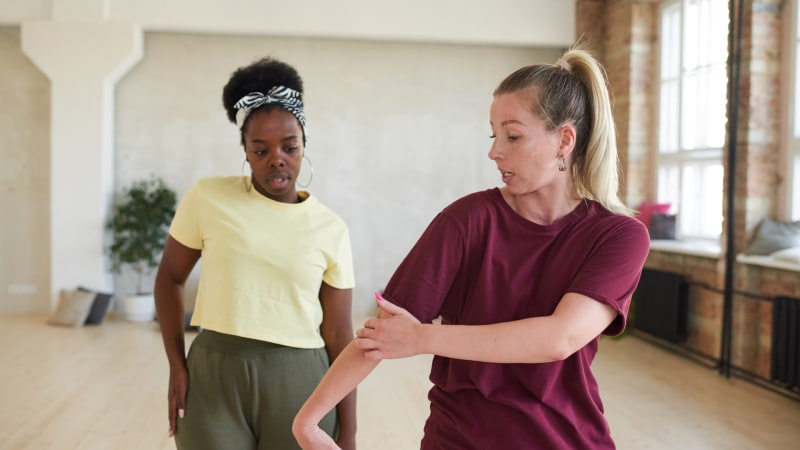 Dance instructor showing a dancer the movement sequences during training in a dance studio