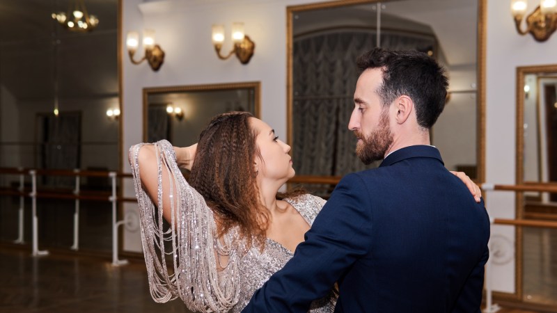 En mand og en kvinde danser en udtryksfuld pardans i en tom balsal