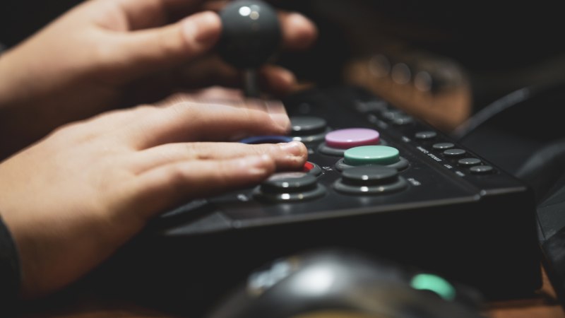 Nahaufnahme der Hände einer Person, die einen Gamecontroller bedient