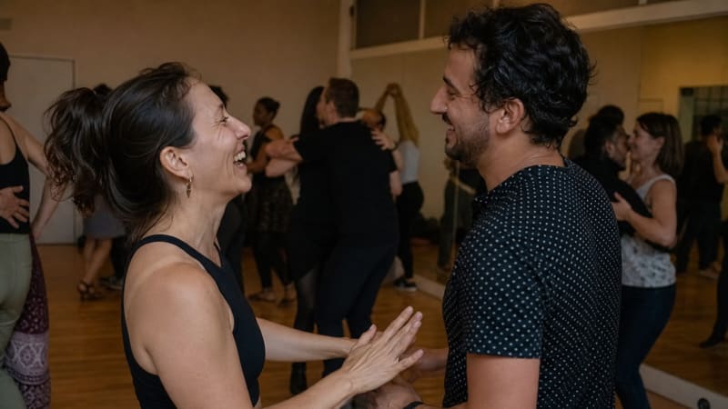 Zwei Freunde lachen entspannt zwischen den Songs am Rand der Tanzfläche, während im Hintergrund die Musik weiterspielt.
