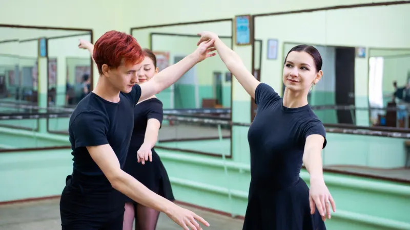 Balletttänzer machen mit ihrer Lehrerin Übungen.