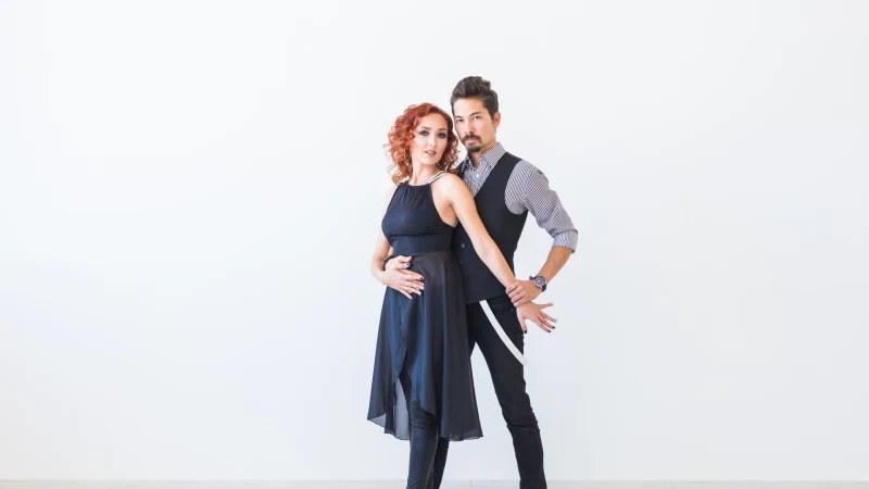 Ein Paar tanzt Bachata vor weißem Hintergrund