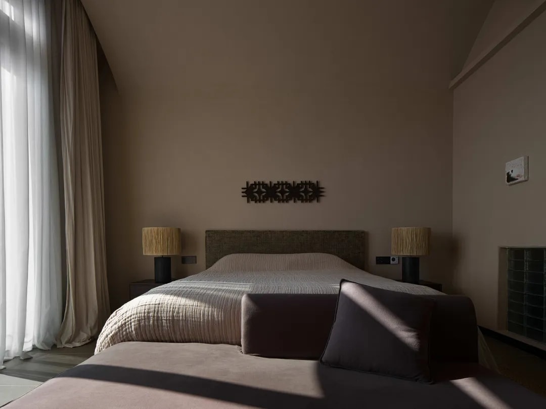 Minimalist bedroom with soft neutral tones and artistic wall treatment