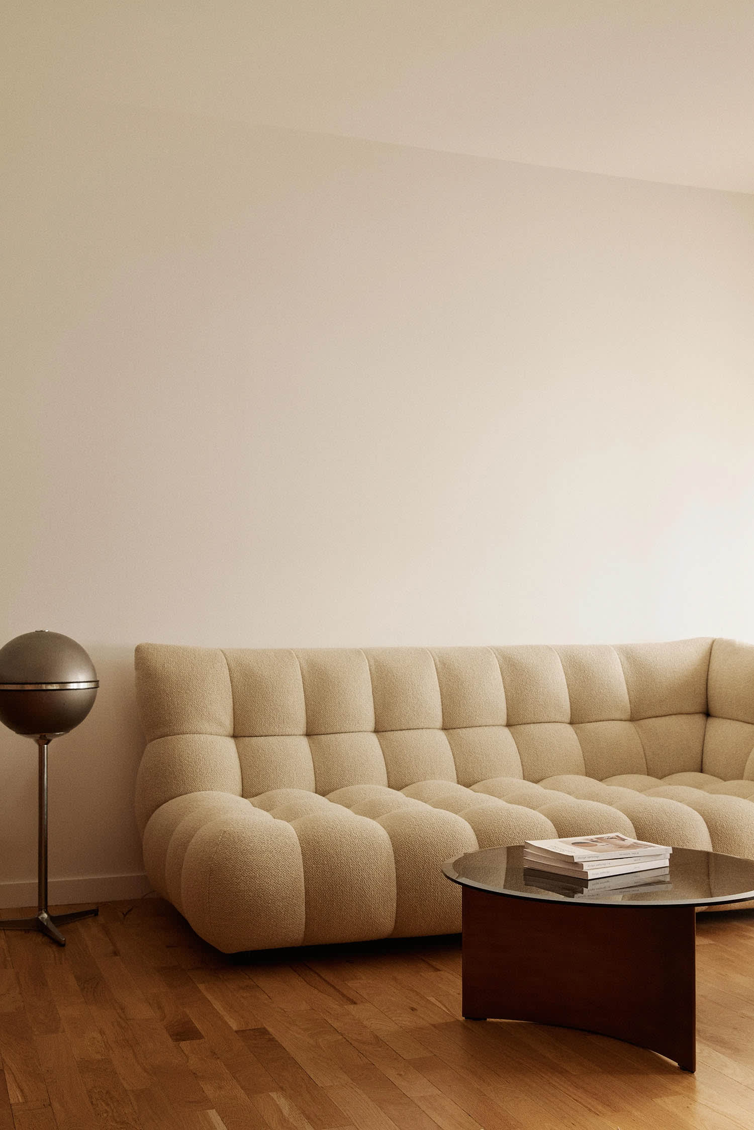 Modernes Wohnzimmer mit geschwungenem Sofa in Beige und organischen Formen