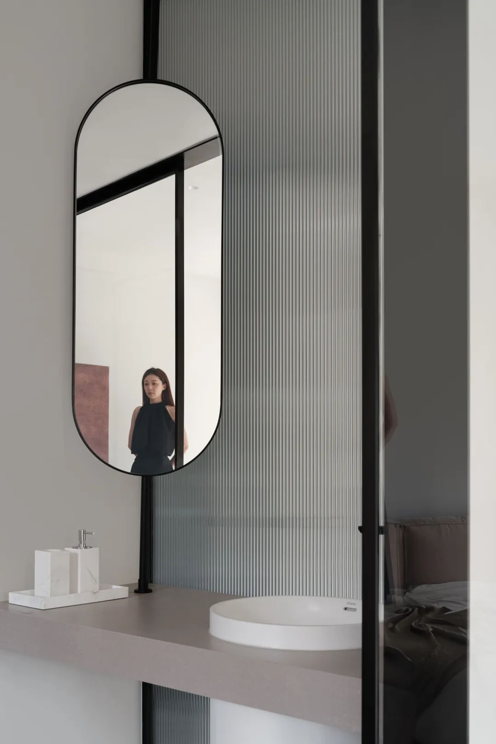 Modern bathroom interior with a glass faucet and minimalist design.