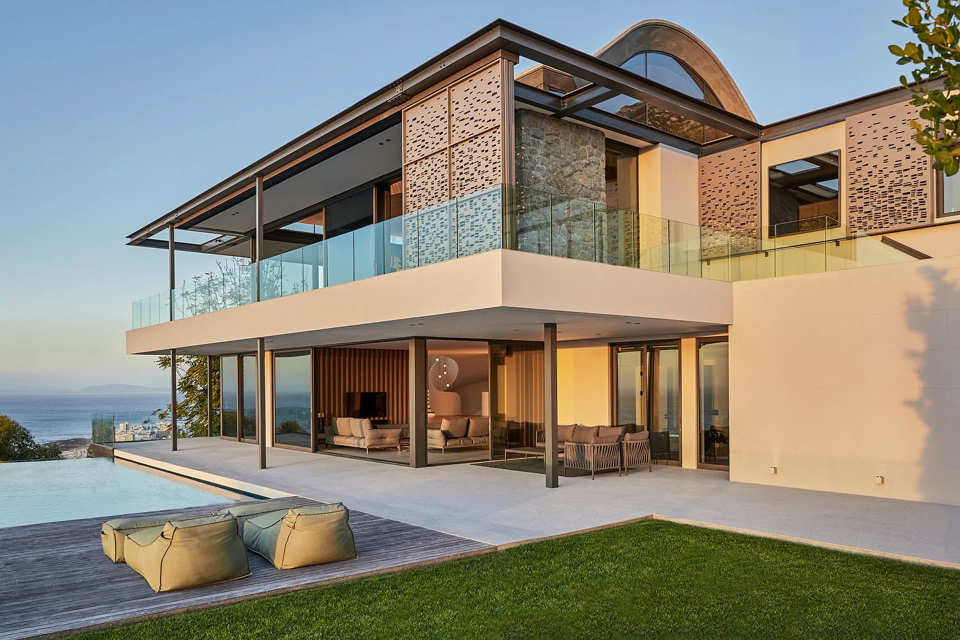 Modern residential exterior featuring concrete, glass, and stone materials.