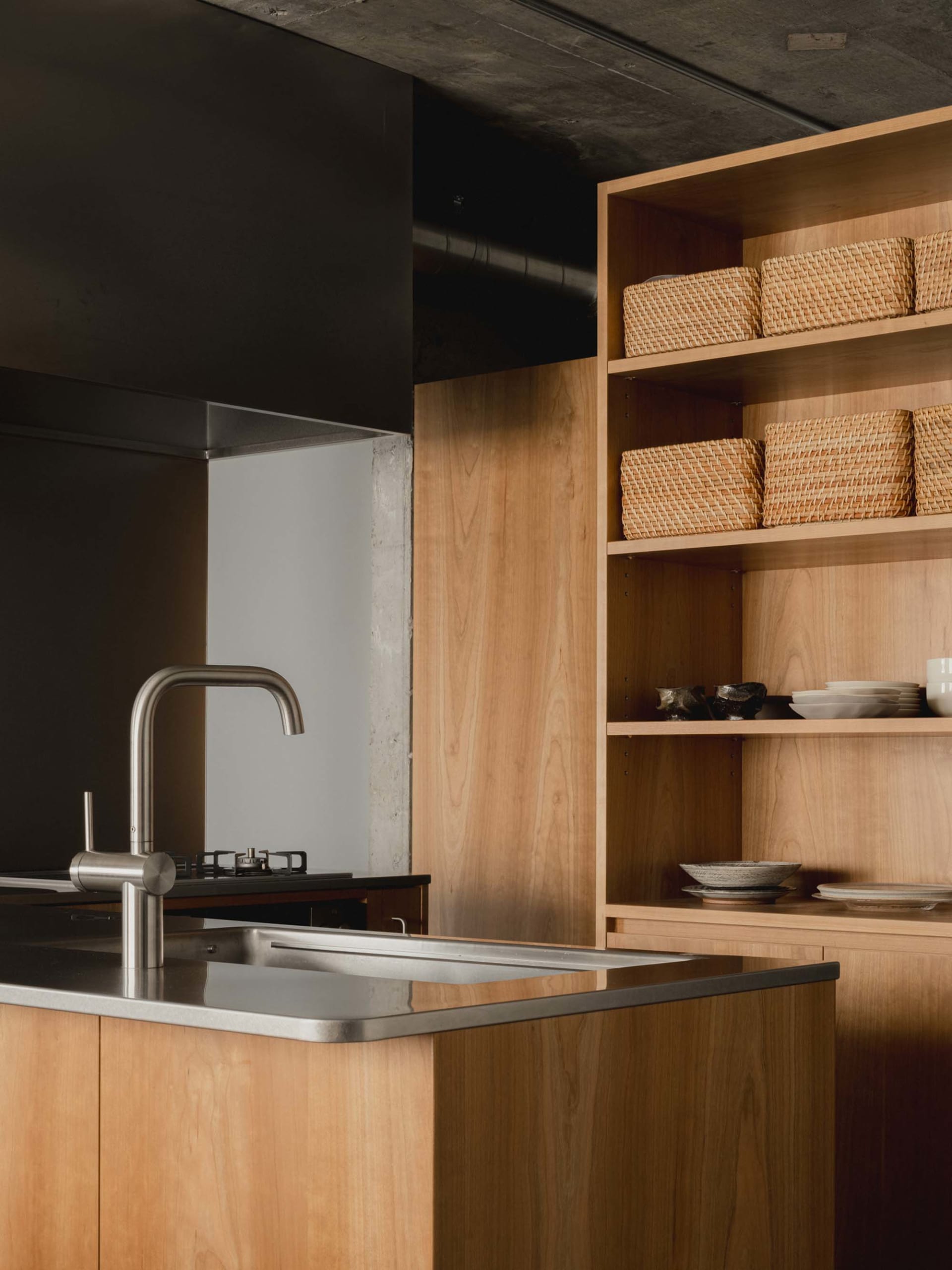 A modern kitchen with wooden cabinets and a stainless steel sink.