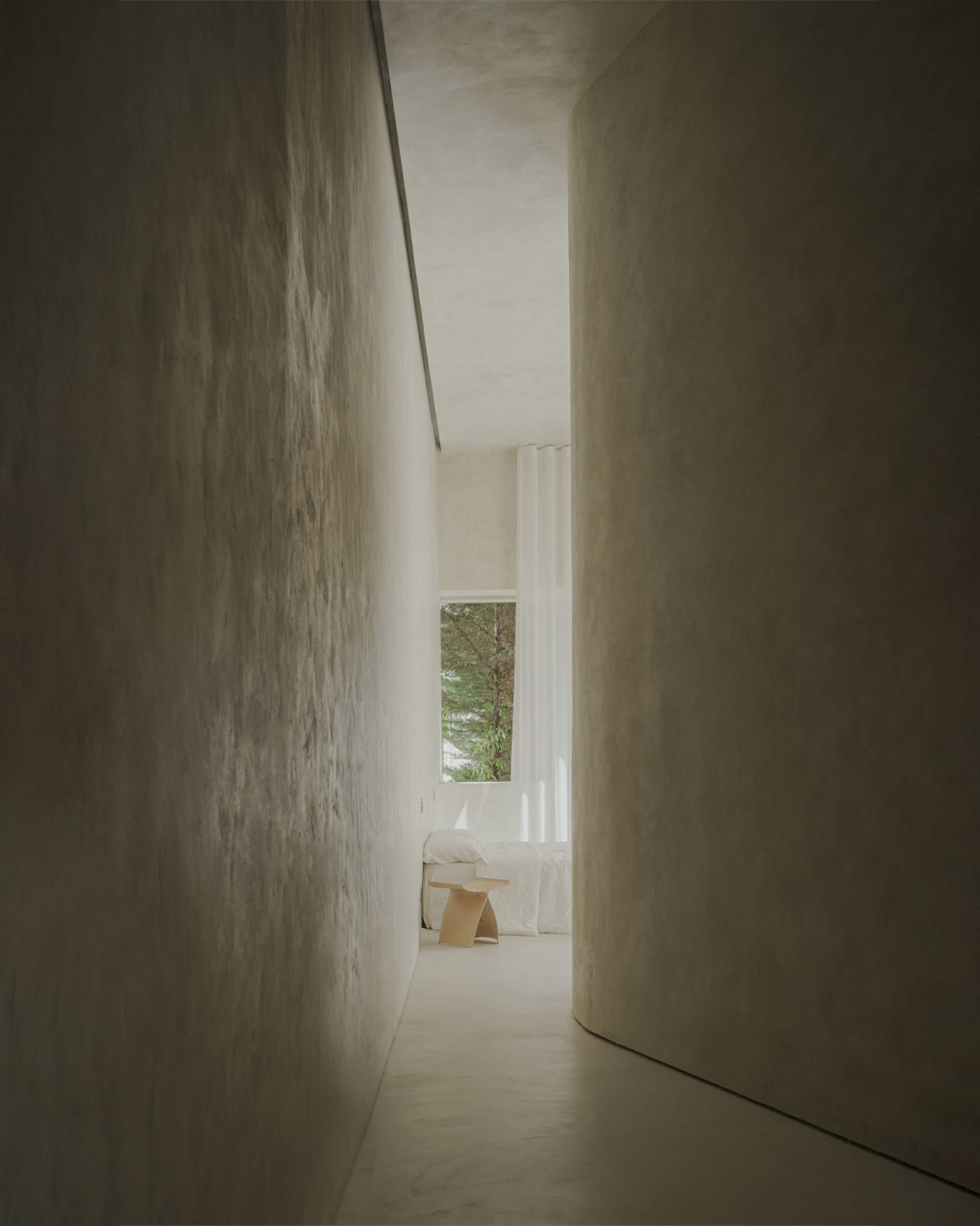 Modern minimalist interior with concrete walls and white furnishings.