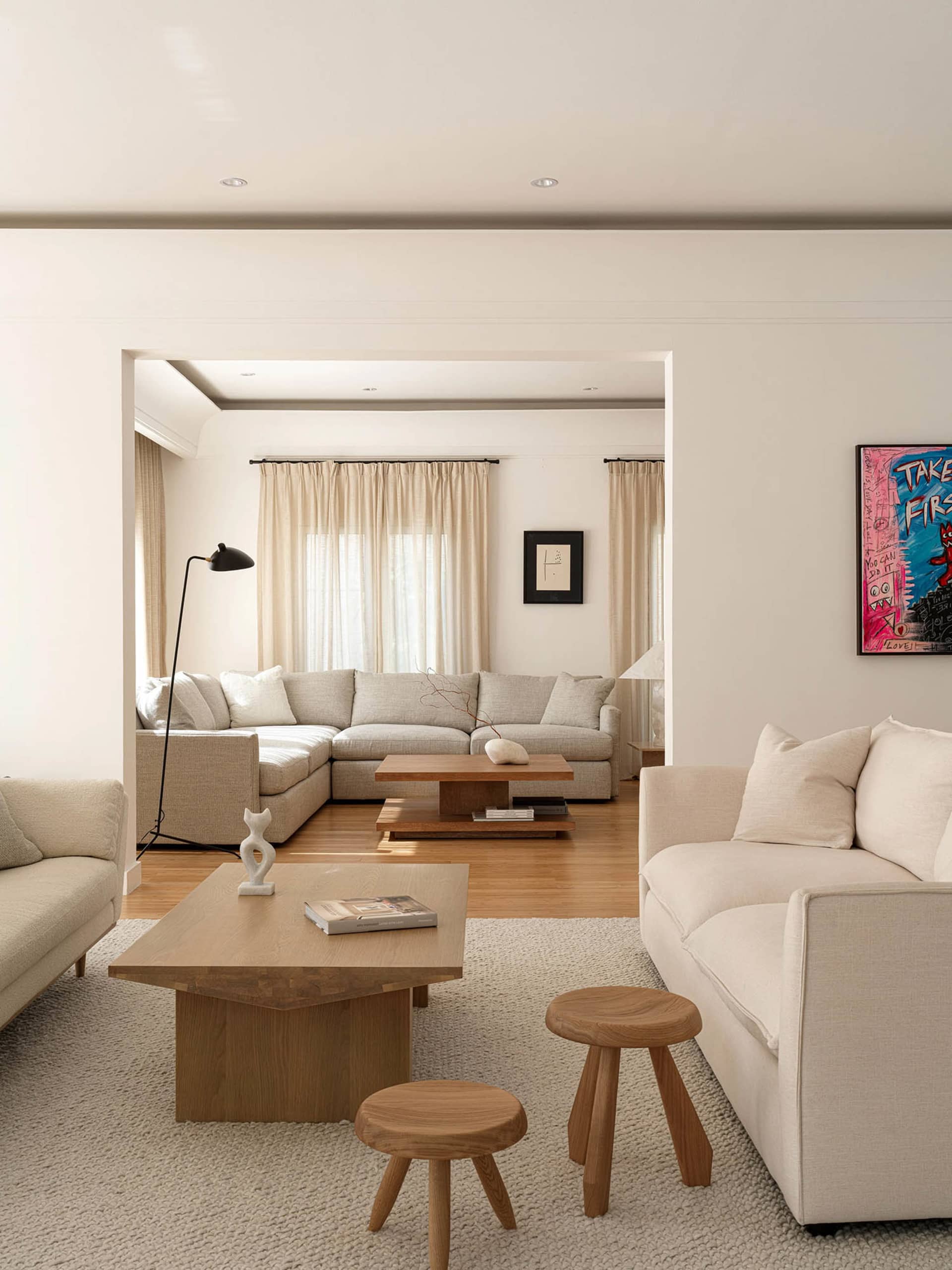 A well-designed, minimalist modern living room with neutral tones and stylish furniture.