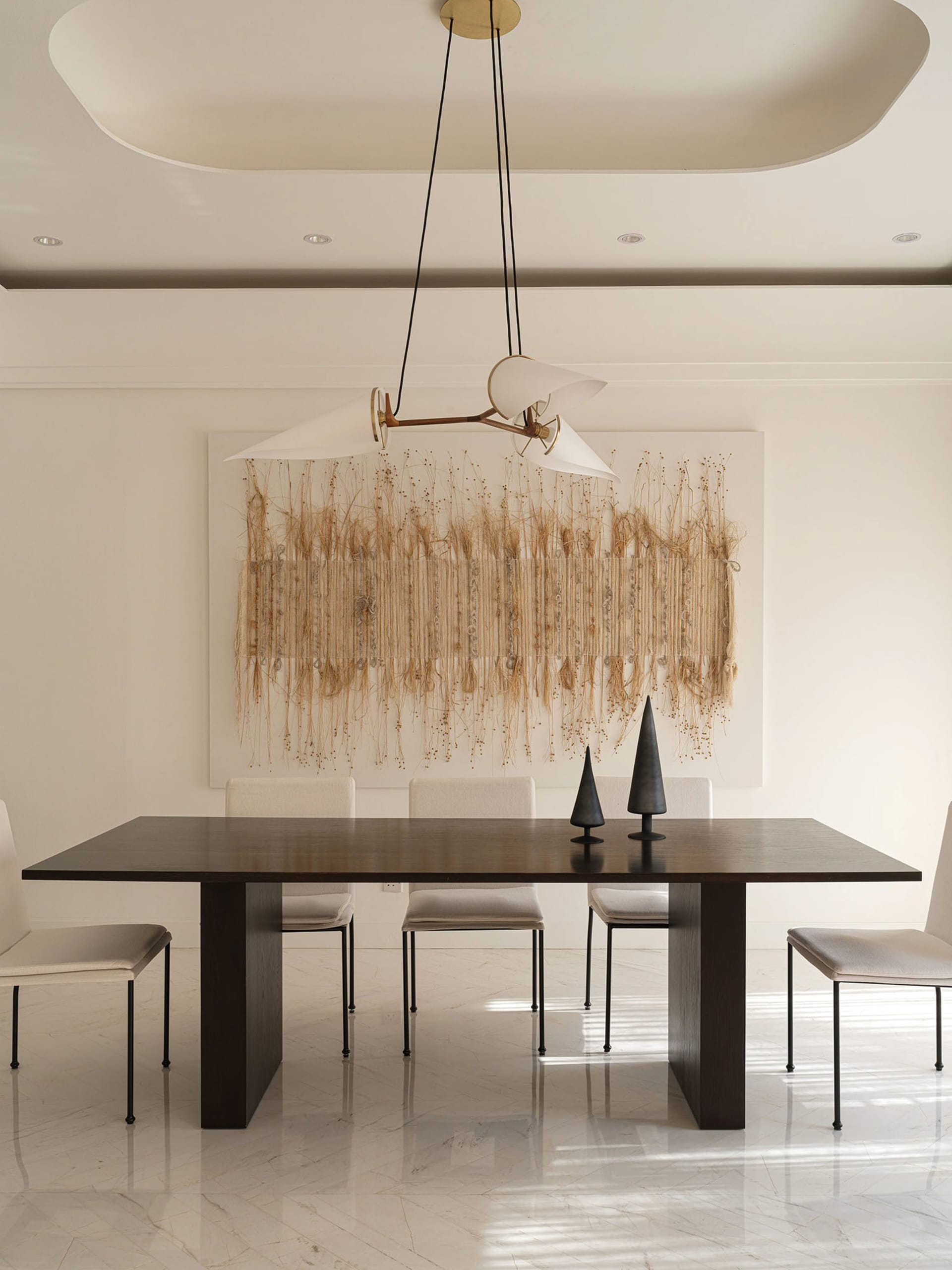 A modern dining room with a dark wooden table, white chairs, and a minimalist white floor with geometric patterns. A unique t