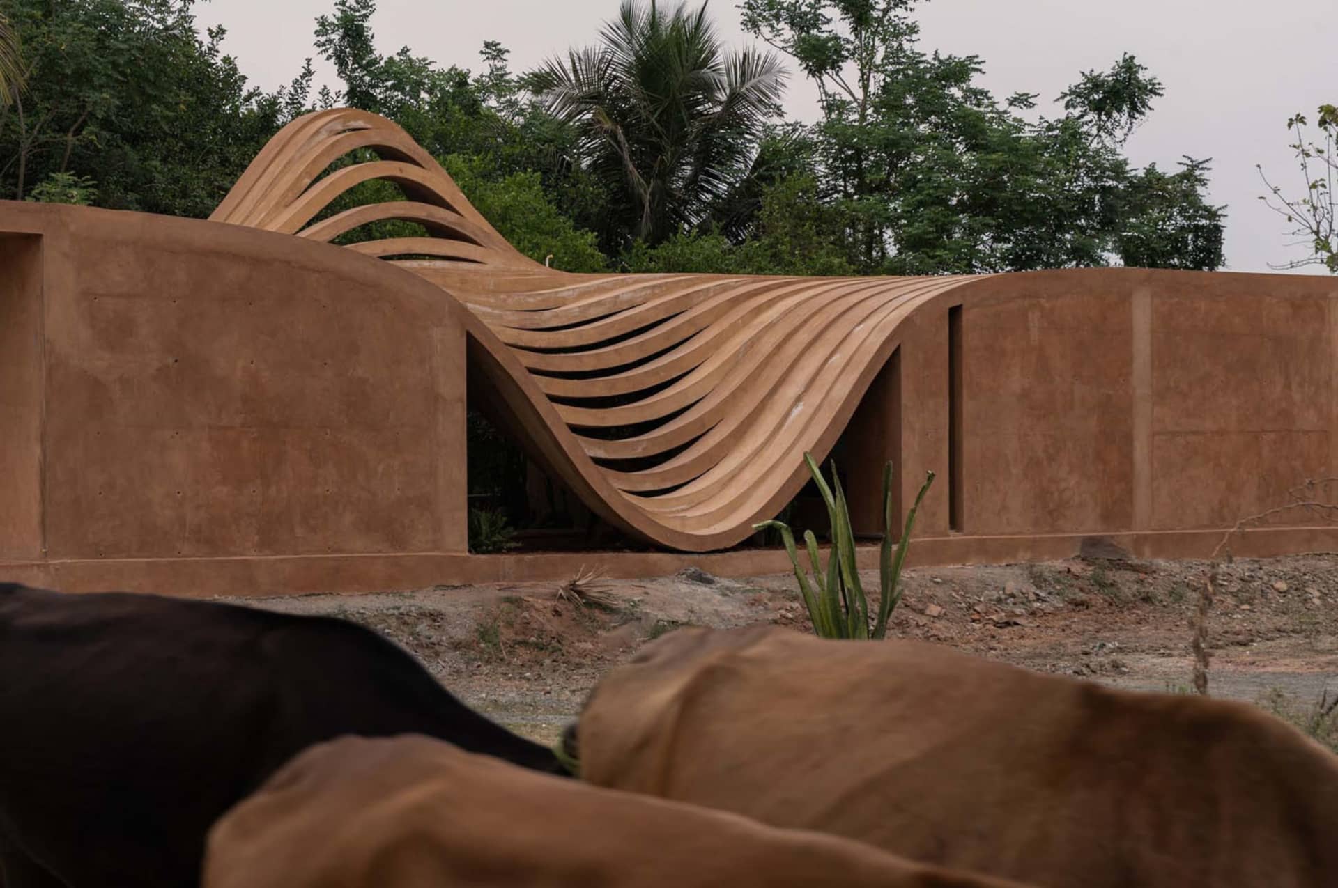 A modern architectural design featuring a wave-like structure made of concrete.
